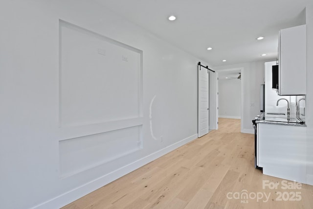 interior space featuring a barn door and light hardwood / wood-style floors