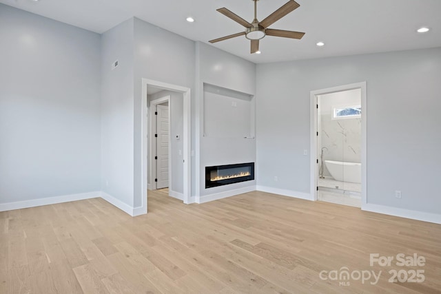 unfurnished living room with ceiling fan, vaulted ceiling, and light wood-type flooring