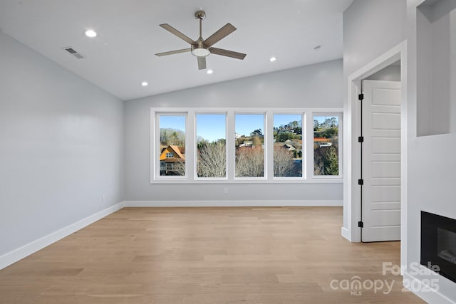 unfurnished living room featuring ceiling fan, vaulted ceiling, and light hardwood / wood-style flooring