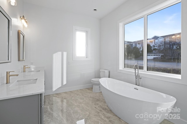 bathroom featuring vanity, toilet, and a bath