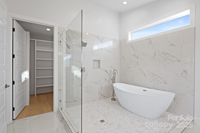 bathroom with plus walk in shower and hardwood / wood-style flooring