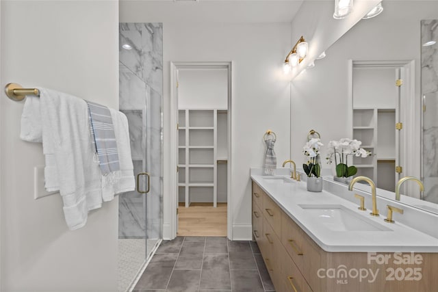 bathroom with walk in shower, tile patterned flooring, and vanity