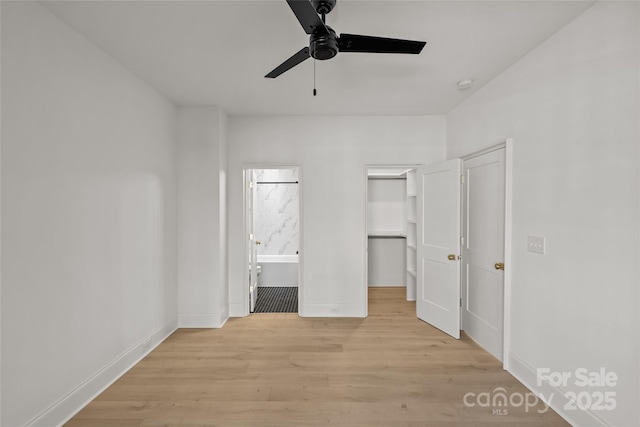 unfurnished bedroom with ceiling fan, a spacious closet, and light hardwood / wood-style flooring