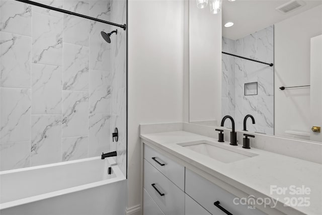 bathroom featuring vanity and tiled shower / bath