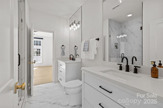 bathroom featuring an enclosed shower, vanity, and toilet