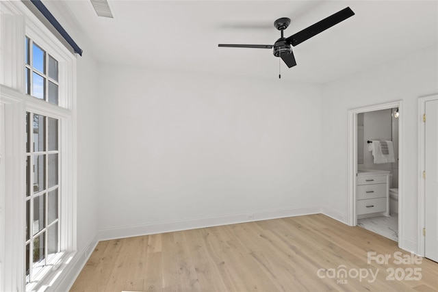 unfurnished bedroom featuring ensuite bath, ceiling fan, and light wood-type flooring