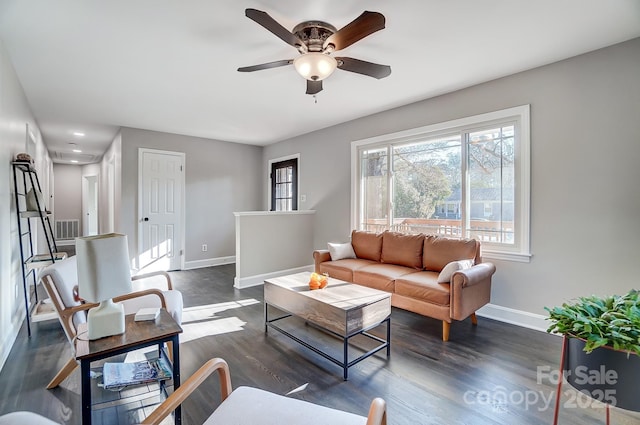 living room with dark wood-type flooring and ceiling fan