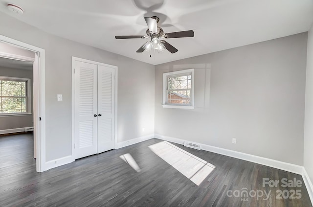 unfurnished bedroom featuring dark wood-type flooring, ceiling fan, lofted ceiling, and a closet