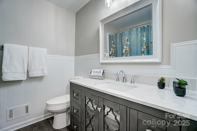 bathroom featuring vanity, hardwood / wood-style floors, and toilet