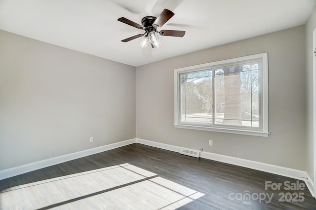 empty room with ceiling fan and dark hardwood / wood-style flooring