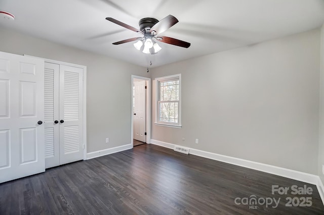 unfurnished bedroom featuring dark hardwood / wood-style flooring, a closet, and ceiling fan