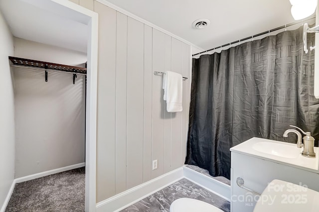 bathroom with toilet, vanity, wooden walls, and a shower with curtain