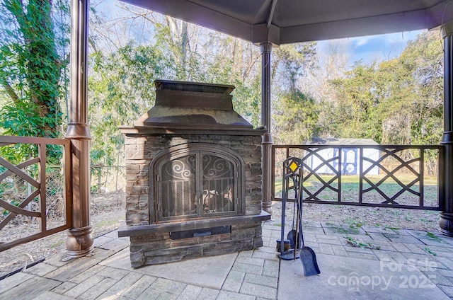 view of patio featuring an outdoor stone fireplace