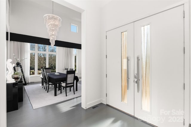 foyer entrance with french doors and a chandelier