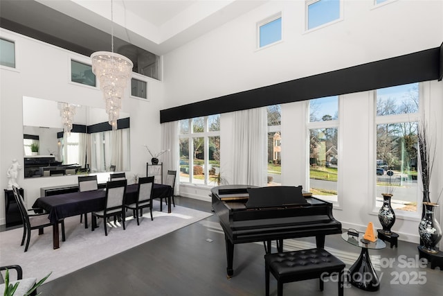 misc room featuring hardwood / wood-style flooring, a towering ceiling, and a chandelier