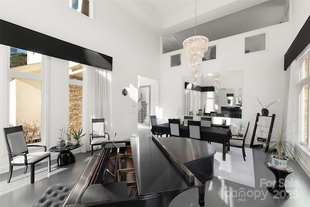 kitchen featuring a towering ceiling, a chandelier, and decorative light fixtures