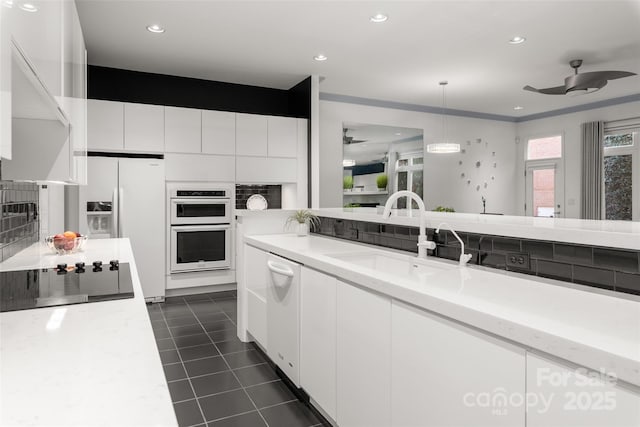 kitchen with pendant lighting, sink, white appliances, ceiling fan, and white cabinets