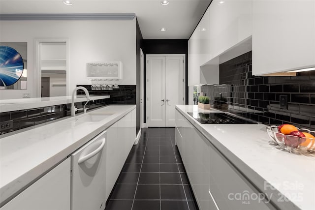 kitchen featuring white cabinetry, sink, dark tile patterned floors, white dishwasher, and black electric cooktop