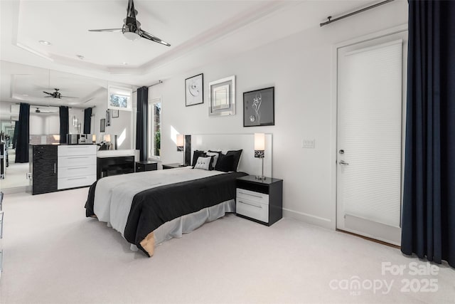 bedroom with a tray ceiling and light carpet