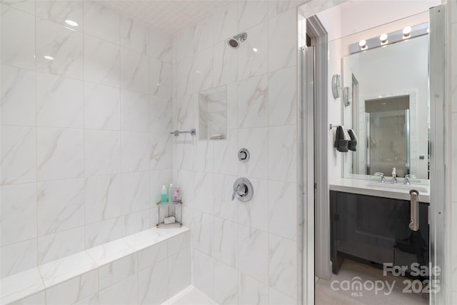 bathroom with vanity and a tile shower