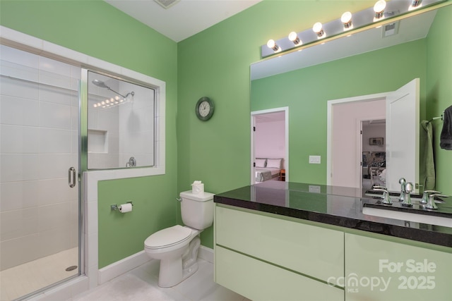 bathroom featuring vanity, a shower with shower door, tile patterned floors, and toilet