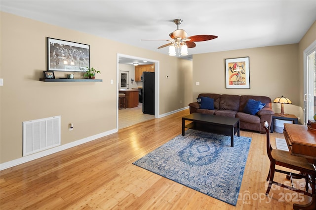 living room featuring ceiling fan and light wood-type flooring