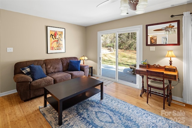 living room featuring light wood-type flooring and ceiling fan