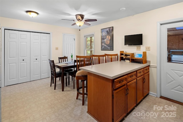 kitchen with ceiling fan, a breakfast bar, and kitchen peninsula