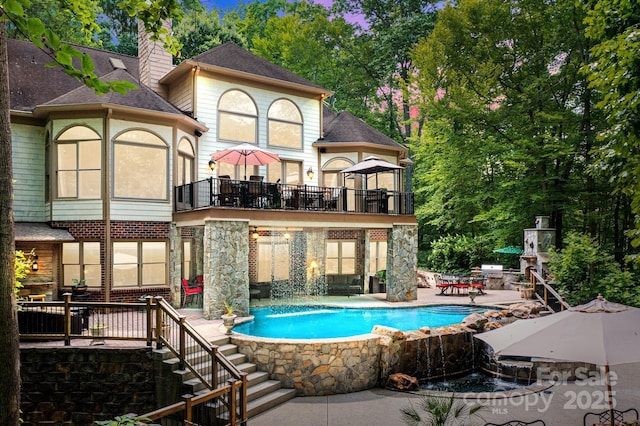 view of pool with a patio area and pool water feature