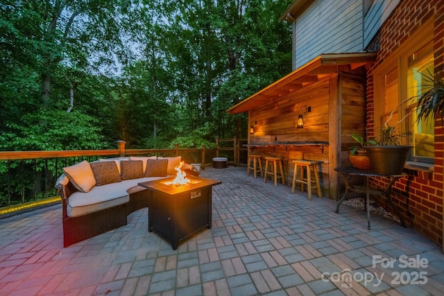 view of patio with an outdoor bar and an outdoor living space with a fire pit