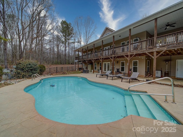 view of swimming pool with ceiling fan and a patio