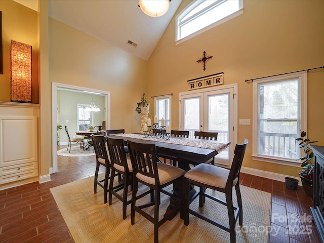 dining room with a towering ceiling and a chandelier