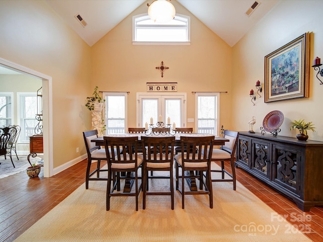 dining area featuring high vaulted ceiling