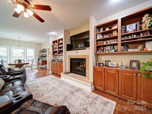 living room with ceiling fan and a tiled fireplace