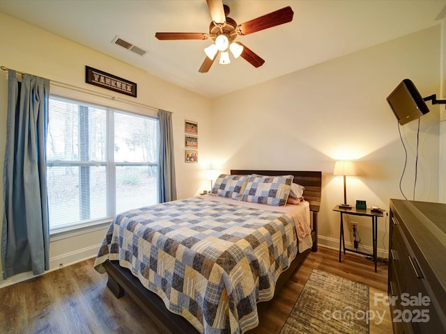 bedroom with multiple windows, ceiling fan, and dark hardwood / wood-style floors