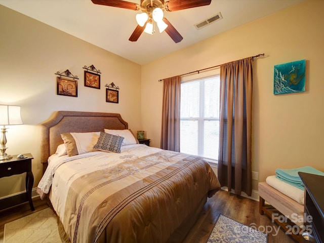 bedroom featuring multiple windows, hardwood / wood-style flooring, and ceiling fan