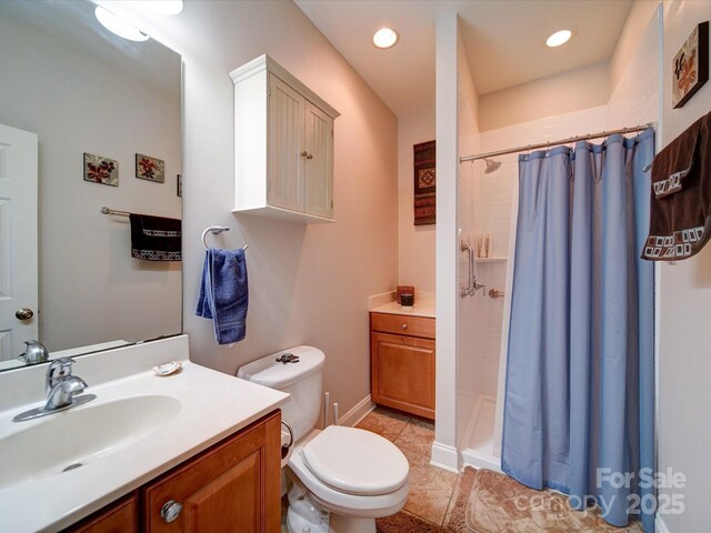 bathroom with tile patterned floors, vanity, toilet, and walk in shower