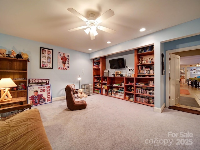 living area featuring ceiling fan and light colored carpet