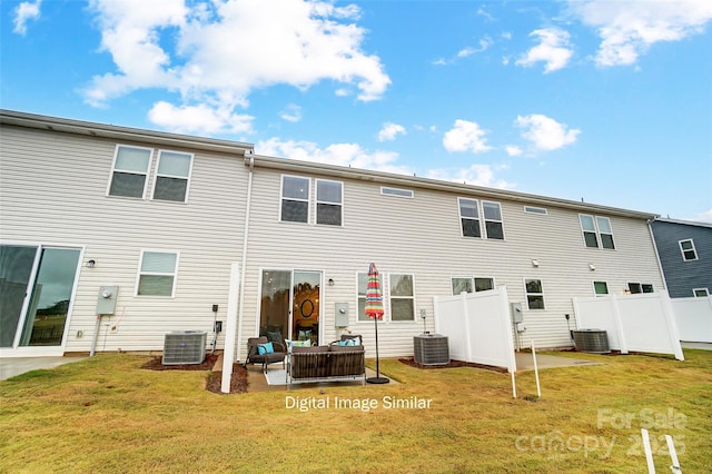 rear view of property with cooling unit and a yard