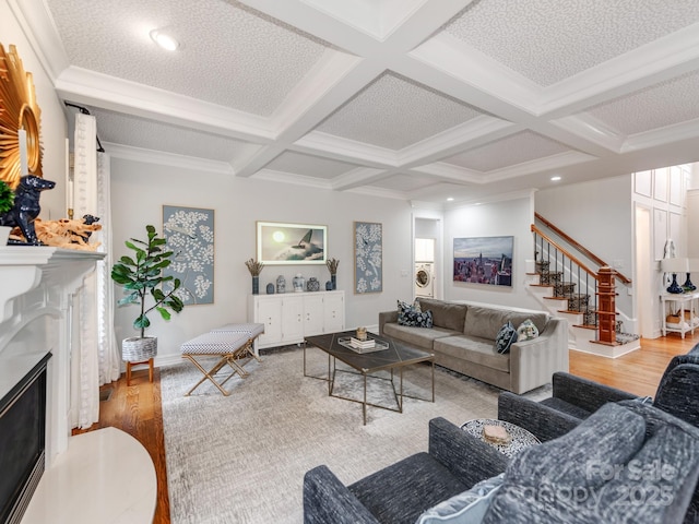 living room with beam ceiling, hardwood / wood-style floors, ornamental molding, and coffered ceiling