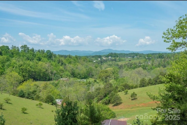 aerial view with a wooded view and a mountain view