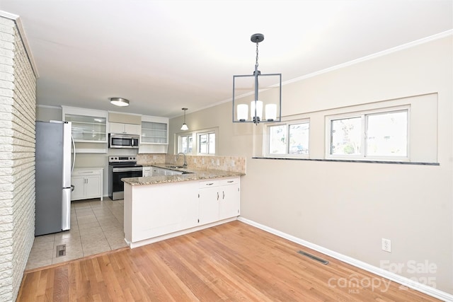 kitchen featuring tasteful backsplash, kitchen peninsula, decorative light fixtures, white cabinets, and appliances with stainless steel finishes