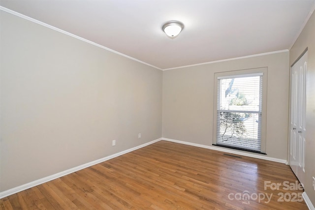 spare room featuring hardwood / wood-style floors and crown molding