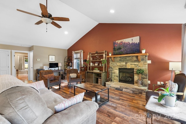 living room featuring ceiling fan, a fireplace, wood-type flooring, and vaulted ceiling