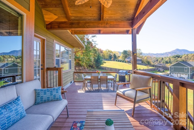 deck featuring a mountain view, ceiling fan, and an outdoor living space