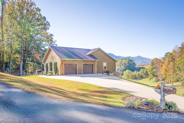 ranch-style house with a mountain view, a garage, and a front yard