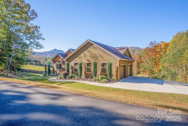 view of front of property with a mountain view, a garage, and a front lawn