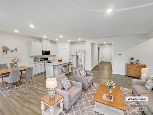 living room with light hardwood / wood-style flooring and sink