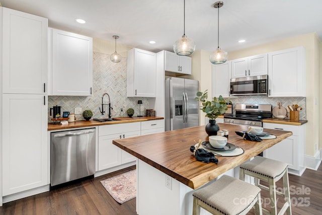 kitchen featuring white cabinets, sink, appliances with stainless steel finishes, and wood counters