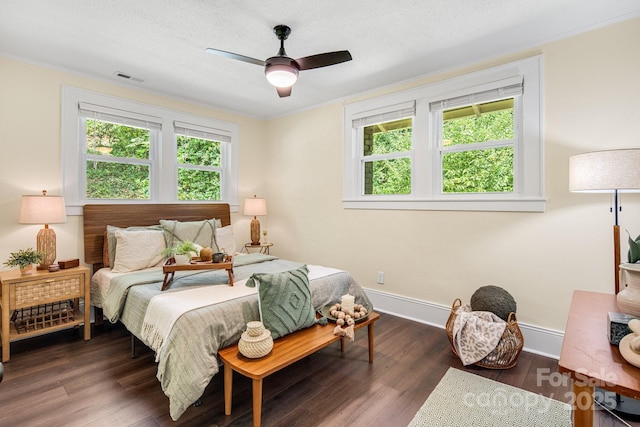 bedroom featuring dark hardwood / wood-style flooring, ceiling fan, and crown molding